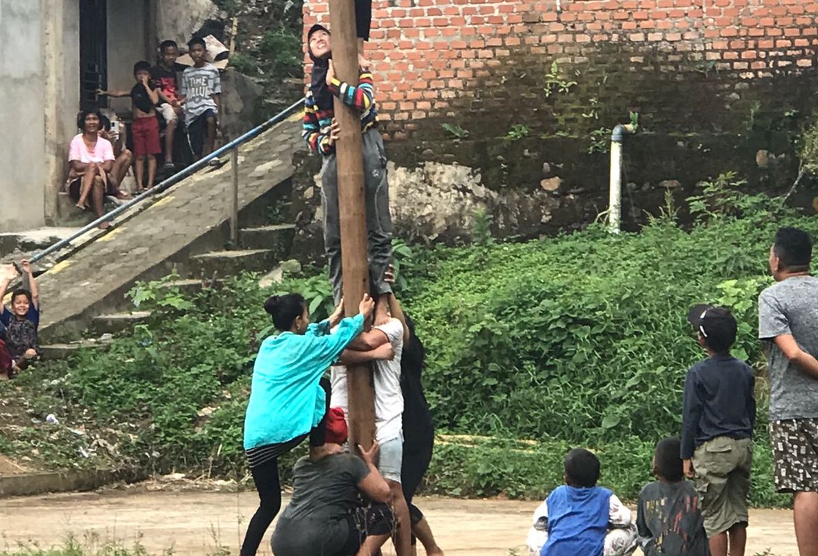 Meski Hujan, Emak-Emak Ini Semangat Memanjat Pohon Pinang