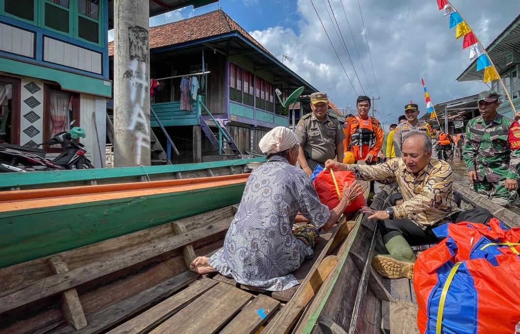 Pakai Perahu, Pj Bupati Muba Bagikan Sembako Bagi Warga Desa Rantau Kroya Terdampak Banjir