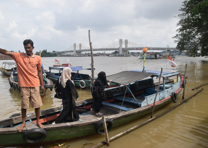 Penumpang menggunakan jasa transportasi air Perahu Ketek di perairan Sungai Musi, Kota Palembang, rabu ( 9/11 ). Untuk sekali menyeberang menggunakan Perahu Ketek ini dari Ulu ke Ilir di kenakan biaya Rp. 8.000.