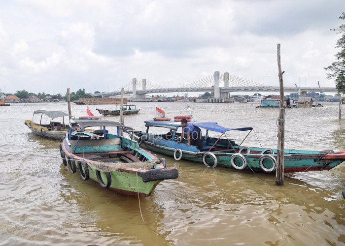 Sejumlah Perahu Ketek bersandar dengan latar belakang jembatan Musi IV di Dermaga Kampung Almunawar, Jl. K.H.A. Azhari, Kel. 13 Ulu, Kec. S. U. I, Kota Palembang, rabu ( 9/11 ). 