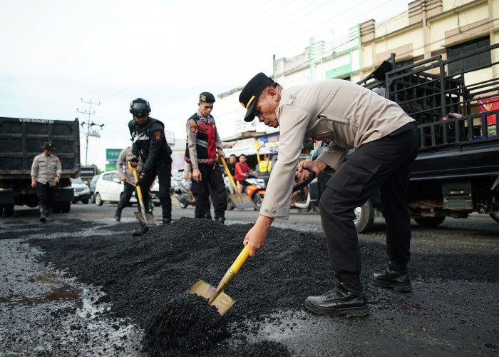 Polres OKI Bersih-Bersih Lingkungan dan Tambal Jalan Kota Kayuagung