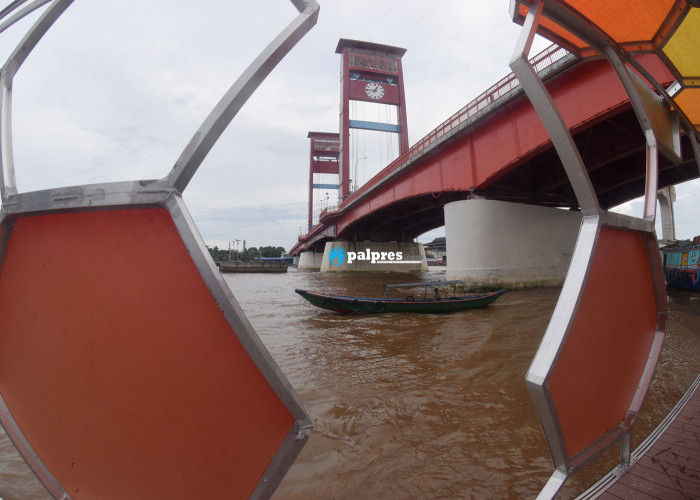 Sebuah perahu ketek melintas disamping Plaza Terminal Jukung kawasan 7 ulu, melewati bawah jembatan Ampera