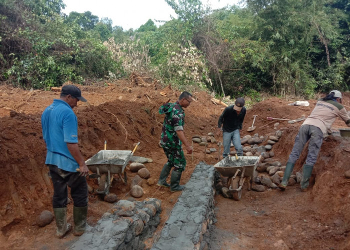 Tanah Becek Tak Halangi Personel TMMD dan Warga Buat Pondasi Plat Duiker