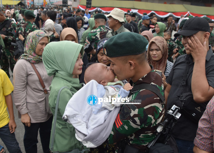 Seorang prajurit TNI dari Yonif Raider 200/BN mencium anaknya dan berpamitan dengan keluarga usai upacara pelepasan dirinya bersama prajurit TNI lainnya
