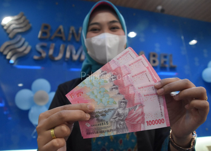 Teller Bank Sumsel Babel menunjukan uang pecahan baru Rp. 100.000 di Kantor Bank Sumsel Babel cabang Jakabaring. Senin ( 7 / 11 ). Foto : Alhadi Farid 