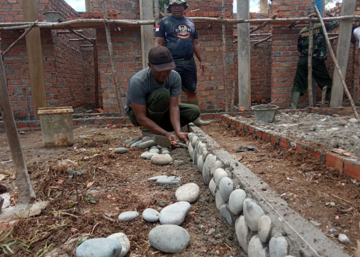 Personel TMMD ke 115 Tempel Pecahan Batu di Jalan Masuk Sarana MCK